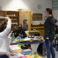In diesem Bild ist eine Lehrerin zu sehen, die eine Gruppe von SchülerInnen in einem Klassenzimmer unterrichtet.
