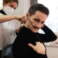 Eine Maskenbildnerin hilft einem Schauspieler beim Anziehen eines Kostüms als Vorbereitung für eine Aufführung.