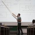 Ein Dozent erklärt mathematische Konzepte an einer Tafel mit einem Diagramm.