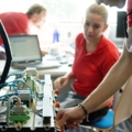 Das Bild zeigt MechatronikerInnen, die mit verschiedenen elektronischen Komponenten arbeiten.