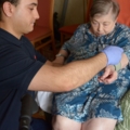 Ein Pflegeassistent kümmert sich um eine ältere Person.