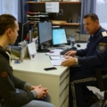 Ein Exekutivbediensteter im Polizeidienst bespricht etwas mit einem Mann in einem Büro.