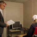 Ein Psychologe führt in einem Labor eine EEG-Messung durch, bei der eine Person mit Elektroden auf dem Kopf untersucht wird.