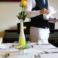 Ein Restaurantfachmann deckt einen Tisch in einem Restaurant ein.