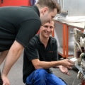 Zwei Servicetechniker reparieren gemeinsam ein Haushaltsgerät.