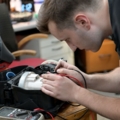 Ein Servicetechniker arbeitet konzentriert mit einem Multimeter an einem Staubsauger.