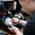 Ein Servicetechniker repariert einen Staubsauger mit einem Multimeter.