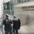 Ein Sozialarbeiter betritt mit seinem Klienten das Gebäude des Landesgerichts für Strafsachen in Wien.