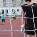 Eine Sozialarbeiterin mit Torwarthandschuhen spielt Fußball.