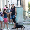 Auf dem Bild ist eine Gruppe von Menschen zu sehen, darunter eine Sozialarbeiterin, die einen Hund an der Leine führt.
