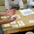 Ein Sozialarbeiter arbeitet mit SchülerInnen und verwendet dazu Karten.