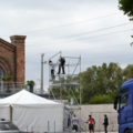 Auf dem Bild sind Veranstaltungstechniker zu sehen, die ein Gerüst aufbauen.