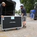Zwei Veranstaltungstechniker bewegen ein großes Transportcase.