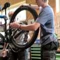 Auf dem Bild ist jemand zu sehen, der an einem Fahrrad arbeitet.