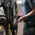Eine Person repariert oder wartet ein Fahrrad in einer Werkstatt.