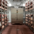 Das Bild zeigt einen Kühlraum mit Fleisch.