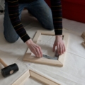 Eine Person ist dabei, einen Holzrahmen zusammenzubauen.