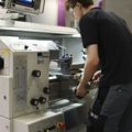 Ein Mann bedient eine Drehmaschine in einer Werkstatt.