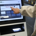 Eine Person nutzt einen Check-in-Automaten am Flughafen.