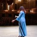 Das Bild zeigt eine Person in einem Theatersaal, die auf der Bühne steht.