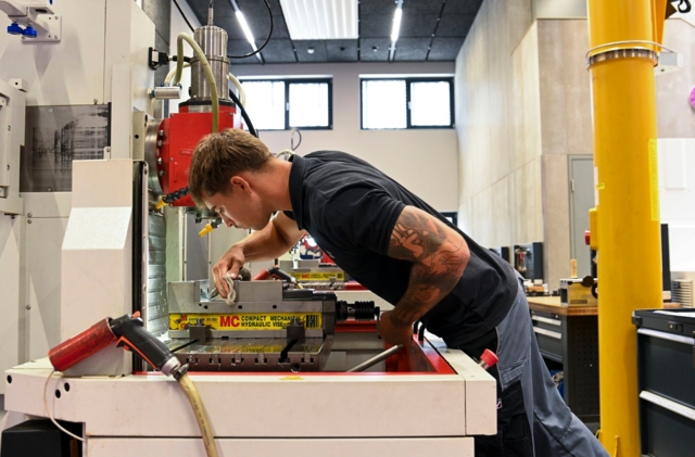 Eine Person arbeitet an einer CNC-Werkzeugmaschine.